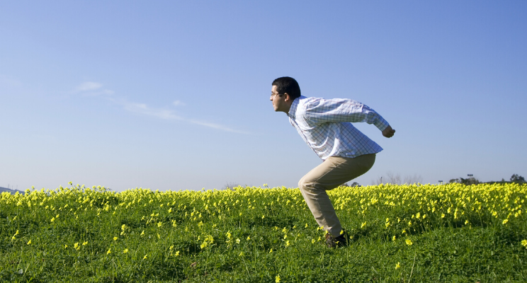 man poised to run in yellow field