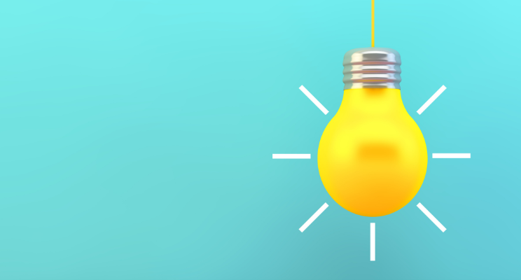 Glowing yellow light bulb on teal background