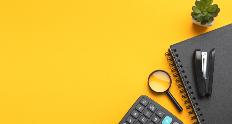 Office supplies: calculator, notebook, magnifying glass