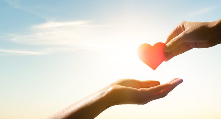 Hand offering heart to open palm