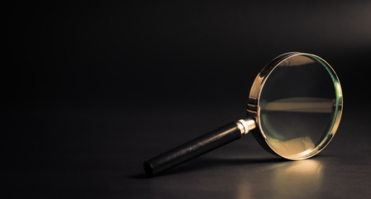 Close-up magnifying glass on dark surface