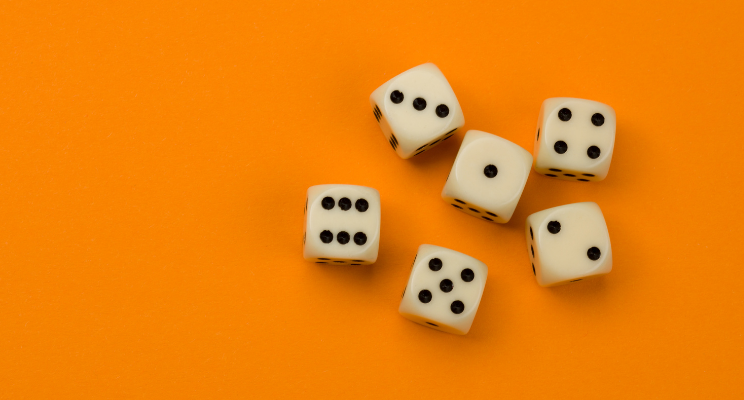 Six white dice with black pips on orange