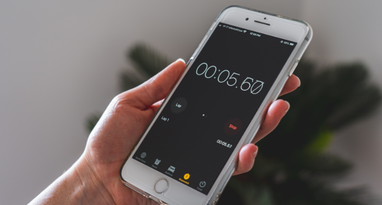 Smartphone stopwatch in hand showing 5 seconds
