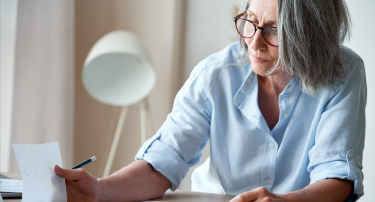 Older woman reviewing documents at desk