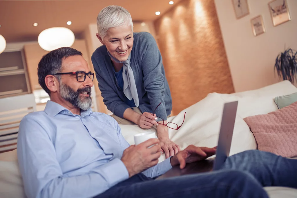 A stock image of a couple looking at a pc, illustrative of Mainstream's HNW and comfortable Los Angeles clients who need wealth management that transcends the normal.